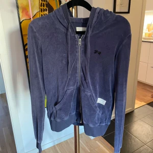 Lila zip hoodie från osd molly - Lila hoodie från odd molly  med dragkedja framtill, huva och fickor. Tillverkad i mjukt bomullsmaterial med ribbade muddar vid ärmslut och nederkant. Liten logga på bröstet och avslappnad passform. Perfekt för en chill och avslappnad stil.