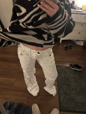 Vita linnebyxor med detaljer - Säljer ett par vita linnebyxor med snygga fickor och knappdetaljer både fram och bak. Byxorna har en loose passform och är perfekta för en avslappnad och trendig stil. Passar dig som gillar bekväma men ändå stilrena byxor. Väldigt långa💗