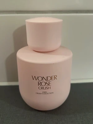 Wonder Rose Crush parfym från Zara - Säljer en Wonder Rose Crush parfym från Zara Crush Collection. Flaskan är ljusrosa med rundad form och har ett stilrent, minimalistiskt utseende. Texten på flaskan är i guld. Perfekt för dig som gillar fräscha och blommiga dofter.70%kvar