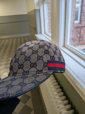 Gucci keps med GG-mönster - keps från Gucci i beige och marinblått med klassiskt GG-mönster över hela kepsen.                                         PRISET GÅR O DISKUTERAS!