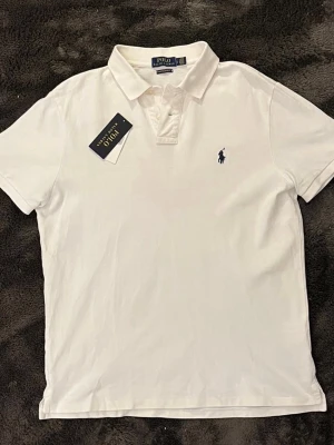 Polo Ralph lauren piké  - Vit polo Ralph lauren piké storlek L, inga fläckar den är i super bra skick. Nypris 1600kr mitt pris endast 499kr, hör av er vid frågor. Mvh Luxury closet🙌😊