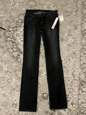 Mörkblå bootcut jeans från Hudson - Snygga mörkblå bootcut jeans från Hudson med klassisk femficksdesign och kontrastsömmar. Jeansen har en något utsvängd passform och är tillverkade i ett mjukt denimtyg med lätt tvättad effekt. Perfekta för en trendig och avslappnad stil.