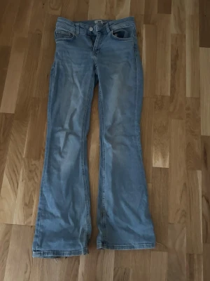 Ljusblå bootcut jeans - Säljer ett par ljusblå bootcut jeans. Jeansen har klassisk femficksmodell och stängs med knapp och dragkedja. De är för stora för mig, därför är de slitna i slutet av benen, jag är 156. Annars inga andra defekter💕💕
