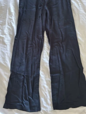 Marinblåa linnebyxor - Snygga marinblåa linnebyxor med avslappnad passform och raka ben. Byxorna är tillverkade i ett lätt och luftigt linnematerial. Perfekta för en chill och stilren look.