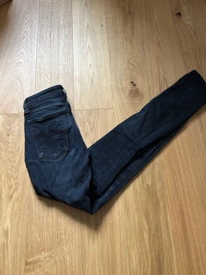 Mörkblå skinny jeans från Nudie - Snygga mörkblå skinny jeans från Nudie Jeans med klassisk femficksdesign och smal passform. Jeansen har diskreta sömmar och är tillverkade i stretchigt denim för extra komfort. Perfekta för en stilren och modern look. Använda några gånger inte många nästan som nya!
