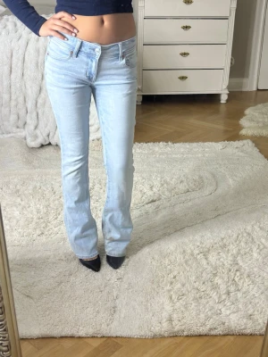 Ljusblå bootcut jeans från Amarican Eagle - Säljer ett par ljusblå bootcut jeans från American eagle som är köpte i usa och har slitage längst ner.