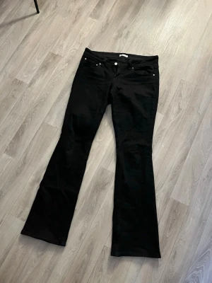 Svarta bootcut jeans från Gina tricot - Säljer ett par svarta bootcut jeans från Gina tricot i storlek 44. Klassisk femficksmodell med normal passform och lätt utsvängda. Superfina fickor bak med knappar. Katt finns i hemmet!