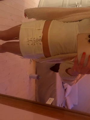 Vit minikjol med snörning - Trendig vit minikjol med snörning framtill och råa kanter nertill. Kjolen har en tight passform och är perfekt till sommaren💕 säljer för att den tyvärr inte kommer till användning längre