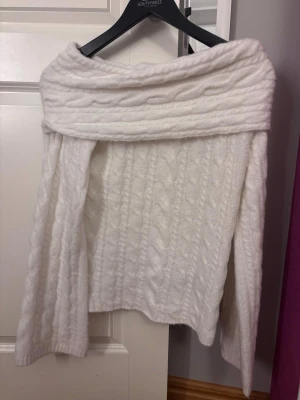 Vit kabelstickad off shoulder-tröja - Säljer en vit superfin kabelstickad tröja med off shoulder-krage. Tröjan har långa ärmar och är gjord i ett mjukt, mysigt material. Perfekt för dig som gillar en stilren och trendig look med extra cozy känsla. Köpt för ca 250 på newyorker💗ALDRIG ANVÄND💗💗