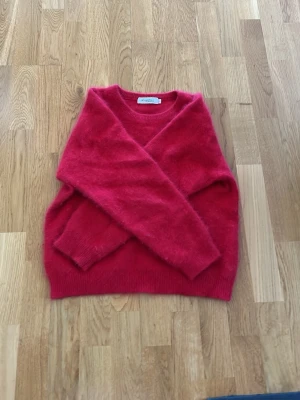 Röd stickad tröja från Rizomic - Mysig röd stickad tröja från Rizomic i storlek XXS. Tröjan har rund halsringning och långa ärmar. Perfekt för kyliga dagar och enkel att matcha med jeans eller kjol.
