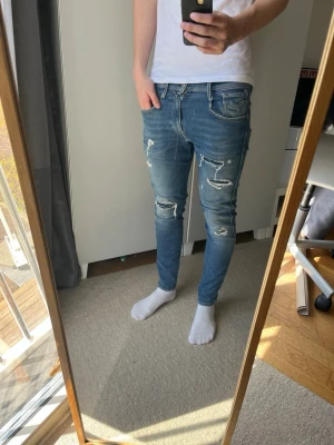 Replay jeans med schyssta slitningar  - Tja! Säljer detta feta paret jeans från Replay| Modell: Bronny, samma passform som anbass| Storlek: 28/30 passar som en 32 i längd| Mycket gott skick, kontakta mig vid minsta fråga! 