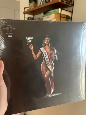 Beyoncé Cowboy Carter vinyl limited - Oöppnad. Säljer en limiterad utgåva av Beyoncé's album 'Cowboy Carter' på dubbel 180g färgad vinyl. Omslaget har en stark visuell design med Beyoncé i centrum och texten 'act ii Cowboy Carter'. Perfekt för samlare och musikälskare. 1st Edition vinyl.