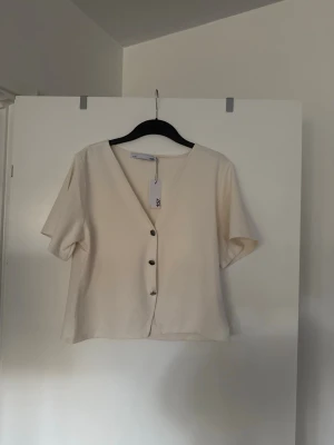 T-shirt med knappar vit  - Storlek XL. Aldrig använd. Köpt i butik så kan finnas skavanker. 