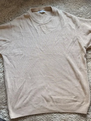 Beige stickad tröja från Zara - Snygg beige stickad tröja från Zara med rund halsringning och ribbade muddar. Tröjan har en enkel och stilren design i mjukt material, perfekt för lager-på-lager och en clean look.  Aldrig använd  (passar M & S storlekar)