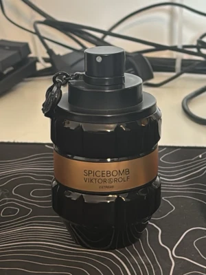 Spicebomb Extreme parfym från Viktor & Rolf - Spicebomb Extreme från Viktor & Rolf är en parfym i en svart, granatinspirerad flaska med guldfärgat band runt mitten. Flaskan har en unik och robust design med en liten kedja vid sprayhuvudet. Perfekt för dig som gillar kryddiga dofter.