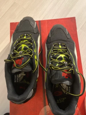 Puma x A$AP Rocky svarta sneakers - Unika Puma x A$AP Rocky sneakers med svart bas, vita detaljer och coola gula flames på sidorna. Skorna har lågt skaft, snörning och en chunky sula. Perfekta för dig som vill sticka ut med streetwear och gillar samarbeten mellan stora märken och artister. Skorna är i bra skick bara använda ett fåtal gånger. Kommer med orginal lådan.