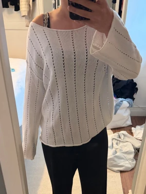 Vit stickad tröja med hålmönster - Vit stickad tröja med hål. Skit snygg till sommaren som en cover up eller till kvällarna. Den är lite genomskinlig, kan ha bara bh under men brukar själv ha linne. Den är från lager 157!