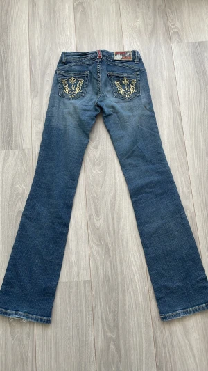 Blå bootcut jeans med brodyr - Snygga blå bootcut jeans från Missy’s jeans med broderade detaljer i guld på bakfickorna. Jeansen är låg midja. 💞💞