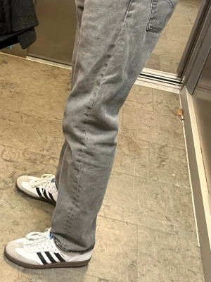 Grå Levis jeans W32 L32 - Säljer ett par grå jeans med rak passform och klassisk femficksdesign. Jeansen har en avslappnad look och är tillverkade i denim. Perfekta för dig som gillar en enkel och stilren vibe. Nyskick! Storlek W32 L32