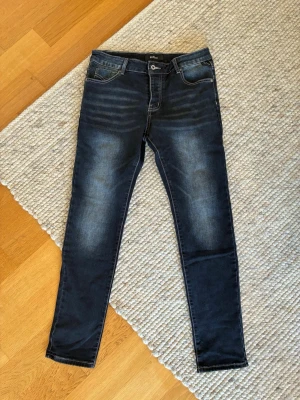 Replay slim fit jeans - Snygga mörkblå skinny jeans från Replay med slitningar och tvättade detaljer på låren. Klassisk femficksmodell med dragkedja och knapp framtill. Jeansen har smal passform och stretchigt material för extra komfort