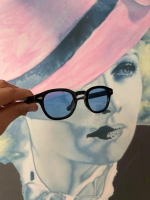 Svarta solglasögon med ljusblått glas - Snygga och trendiga svarta solglasögon med en klassisk form. De har blåa linser och en stilren design som passar perfekt för soliga dagar. ☀️ En tidlös accessoar för den modemedvetna. Skicka 10/10. Priset är inte hugget i sten så skicka gärna prisförslag✅ Skriv vid frågor eller funderingar i DM🍾