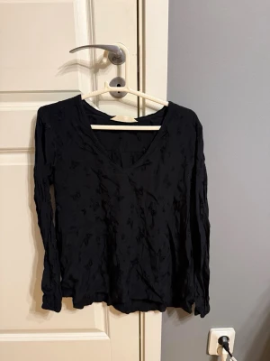 Svart långärmad blus med v-ringning - Svart blus med v-ringning och långa ärmar från Odd Molly, använd cirka 5 gånger. Storlek XS/S.