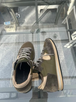 Philippe Model sneakers 41 – grön/brun - Säljer mina Philippe Model Paris sneakers i storlek 41. Sjukt snygg färgkombination i olivgrönt, brunt och beige – passar till typ allt.  Material: läder, mocka & mesh med gummisula.  Använda såklart, finns slitage (se bilder) men fortfarande mycket liv kvar. Perfekta om du vill ha designerskor till ett bra pris.  📦 Snabb frakt 💬 Bara att skriva vid frågor