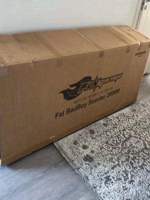 Fat BadBoy Scooter 2000W elskoter - Säljer en svart Fat BadBoy Scooter 2000W med 20Ah batteri. Elskotern har breda däck, robust ram och en bekväm sits. Perfekt för dig som vill ha en kraftfull och cool elskoter för stadskörning eller cruising. Levereras i originalkartong. Och den är helt ny  i paketet 