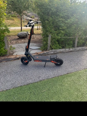 Kukirin G2 - Säljer en svart elektrisk elscooter av modellen G2 med orange detaljer. Scootern har robust ram, stora däck och LED-belysning under ståplattan. Perfekt för att ta sig fram snabbt i stan. Laddare medföljer. 10 pack bromsar ingår samt laddare och led lights. Använd i 5 månader och funkar helt felfritt med inga problem. 