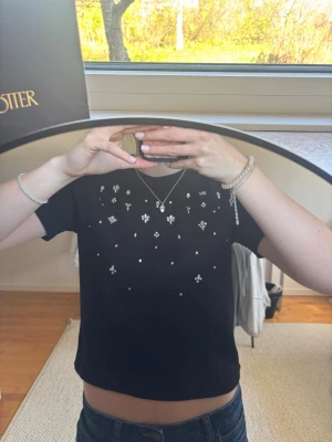 Svart topp med diamanter  - Super snygg svart topp med diamanter på framsidan. Är i storlek M, men väldigt liten i storleken och sitter mer om en S/XS