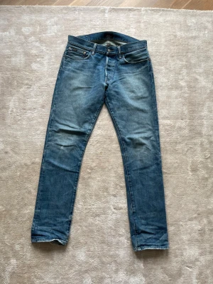 Blå raka jeans från Polo Ralph Lauren - Säljer ett par klassiska blå jeans från Polo Ralph Lauren med rak passform och fem fickor. Jeansen har en snygg tvättad look och är tillverkade i slitstarkt denim. Perfekta för en avslappnad stil och funkar till det mesta.