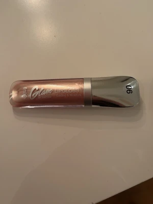 Glam of Sweden Lipgloss 06 - Endast testad på min hand en gång!Snyggt läppglans från Glam of Sweden i nyansen 06. Färgen är ljusrosa med en skimrande finish och kommer i en smidig tub med silverfärgat lock. Perfekt för dig som vill ha glansiga och återfuktade läppar. 