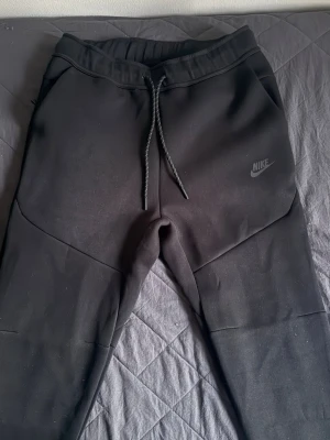 Svarta nike tech byxor - Svarta nike tech byxor, helt nya och oanvända. Storleken är S, byxorna passar mig inte så fråga inte om bild med de på. Kom dm för fler bilder och om ni har frågor.