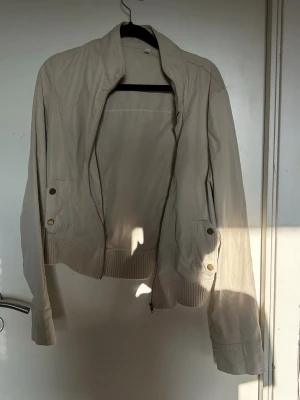 Beige Tunn Jacka - knappt använd, fickan gick dock sönder efter en tvätt men annars är den i jätte fint skick. asiatisk storlek L, sitter som en XS-S.
