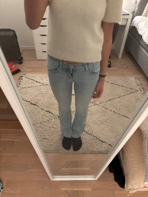 Ljusblå bootcut jeans - Säljer ett par ljusblå bootcut jeans med klassisk femficksdesign och normal midja. Jeansen har en avslappnad passform över låren och lätt utsvängda ben. Perfekta till en enkel topp eller hoodie för en chill look. Köptes på sellpy💓