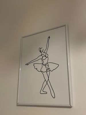 Tavla - Snygg tavla med minimalistisk linjeteckning av en ballerina i svart på vit bakgrund. Motivet är inramat i en enkel vit ram som ger en stilren känsla och passar perfekt som dekoration i hemmet.