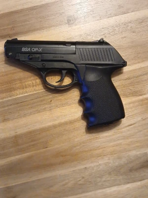 BSA OP-X luftpistol svart - Säljer en svart BSA OP-X luftpistol i metall och plast med ergonomiskt grepp och tydliga fingerfördjupningar. Pistolen har en smidig design och är enkel att ladda genom att skjuta handtaget åt sidan. Perfekt för dig som gillar luftvapen och skytte.