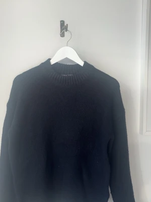 Svart stickad tröja NA-KD - En svart stickad tröja från NA-KD med rund halsringning och ribbstickade muddar. Tröjan har en enkel och stilren design som passar perfekt till lager-på-lager och är ett måste i garderoben för kyligare dagar. I storlek xxs men passar xs skulle jag säga.