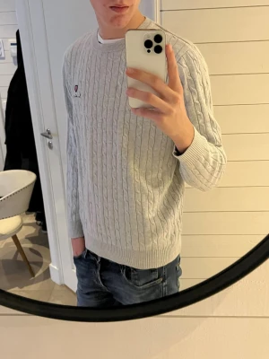 Ljusgrå kabelstickad tröja från Bondelid - Säljer en ljusgrå kabelstickad tröja från Bondelid i storlek M passar S skulle jag mer säga. Tröjan har rund hals, lång ärm och broderad logga med sköld på bröstet. Klassisk och stilren modell som passar perfekt till jeans. Hör av dig om du har några frågor?