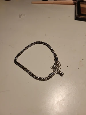 Silverfärgat kedjearmband - Snyggt silverfärgat armband med flätad kedja och justerbar kedja med liten kula vid låset. Passar perfekt för dig som gillar stilrena accessoarer och vill ha något som funkar till många olika looks.