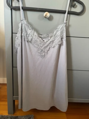 Ljusgrått linne med spets - Säljer ett ljusgrått linne med spets