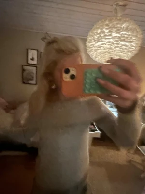 Ljusbeige stickad off shoulder-tröja - Trendig ljusbeige stickad tröja med off shoulder-design och långa ärmar. Mjuk och skön passform, perfekt för att skapa en avslappnad men ändå snygg look. Passar till jeans eller kjol för en casual stil.