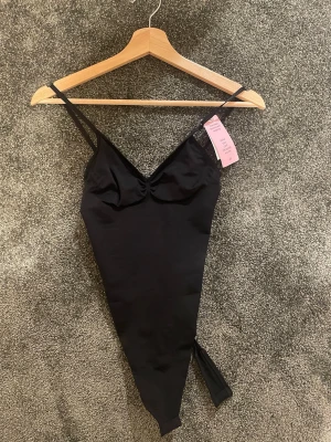 Svart body från h&m - Snygg svart body från h&m med smala axelband och v-ringning. Helt ny med prislapp!!!