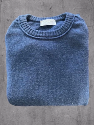 Blå stickad tröja från Gran Sasso - Mysig blå stickad tröja från Gran Sasso med klassisk rund halsringning och ribbade muddar. Storleken är M men passar S.