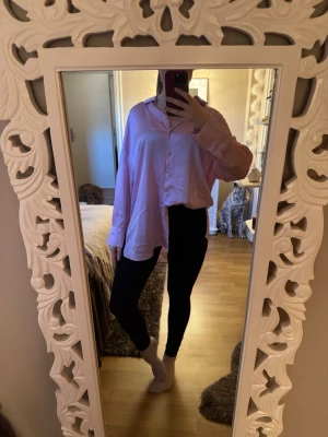 Ljusrosa oversized skjorta från Zara - Ljusrosa siden skjorta från Zara i oversized modell med klassisk krage och knäppning framtill. Perfekt att styla med jeans, kjol eller över bikinin. 