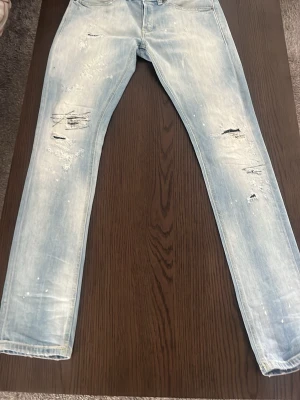 Dondup jeans - Säljer ett par ljusblå skinny jeans med slitningar utan defekter. Jeansen har en tvättad look och smal passform som ger en trendig vibe. Perfekta för dig som gillar streetstyle och vill ha ett par jeans med attityd. Pris kan diskuteras 😁