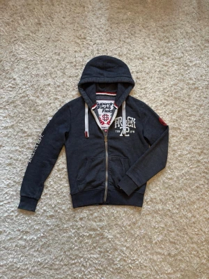 Superdry zip hoodie grå  - Snygg zip hoodie från superdry. Mycket bra skick, storlek S!