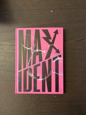Stray Kids MAXIDENT album rosa - Säljer Stray Kids MAXIDENT album i stark rosa färg med svart text och pilgrafik på framsidan. Boken har hårdpärm och är designad med en modern, grafisk stil. Perfekt för dig som gillar K-pop och samlar på snygga album. Kan fattas något klistermärke
