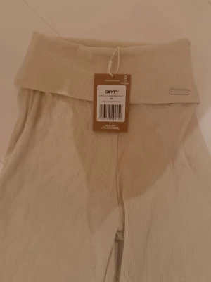 Beige ribbade leggings från Aim'n - Säljer ett par beige ribbade leggings från Aim'n med hög midja och utsvängda ben. Tillverkade i mjukt stretchigt material som sitter skönt på kroppen. 