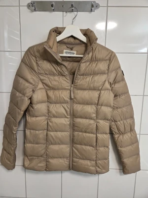 Beige lättvikts jacka stl 32 / 34 ( XS ) från Kappahl  - Beige lättvikts jacka stl 32 / 34 ( XS ) 90% dun och 10 % fjäder , i märket Hampton republic , använd 1 - 2 ggr 
